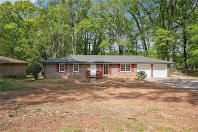 Ranch-style home with brick siding, an attached ga