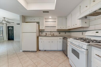 Kitchen featuring white appliances, a sink, under