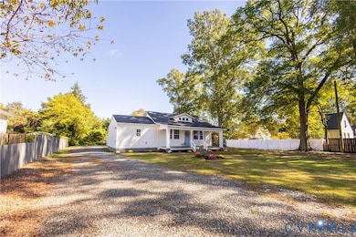 Back of property featuring a porch and gravel driveway