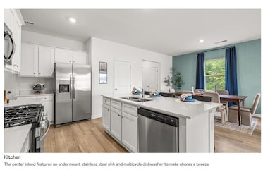 Kitchen with white cabinetry, appliances with stainless steel finishes, an island with sink, light wood-style floors, and recessed lighting
