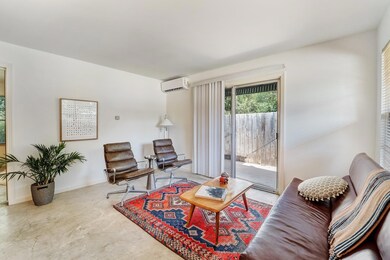 Living room with a wall mounted AC and concrete f
