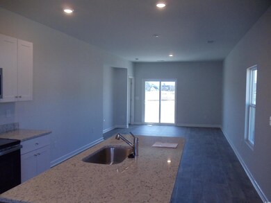 Kitchen with light stone counters, open floor plan