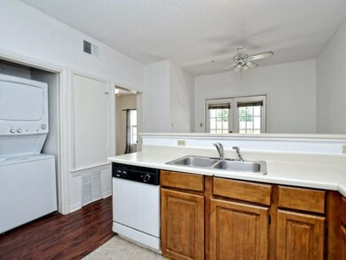 Kitchen with stacked washer and clothes dryer, di
