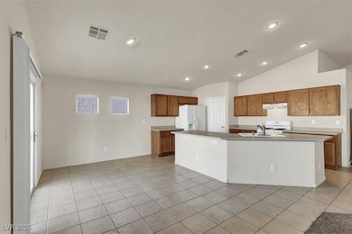Kitchen featuring white appliances, brown cabinets