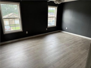 Empty room with wood finished floors and a ceiling fan