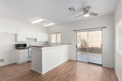 Kitchen featuring stainless steel microwave, white