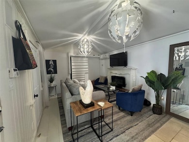 Living room featuring a chandelier, a fireplace, and vaulted ceiling