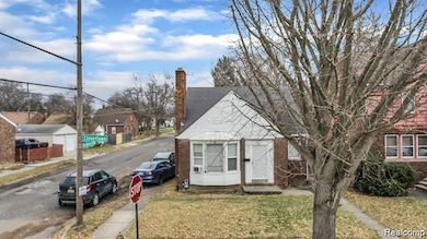 View of front of home featuring a chimney, a front lawn, and brick siding
