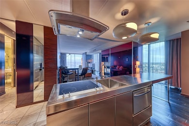 Kitchen featuring stainless steel countertops, a sink, black electric cooktop, modern cabinets, and open floor plan