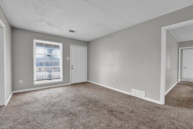 Carpeted spare room with baseboards, a textured ce
