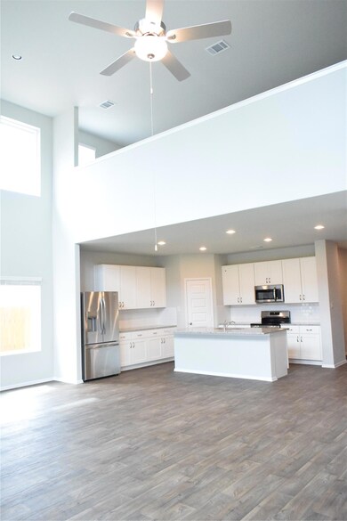 Kitchen featuring a towering ceiling, fridge, whi