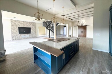 Kitchen featuring pendant lighting, dark hardwood / wood-style floors, blue cabinetry, a fireplace, and a kitchen island