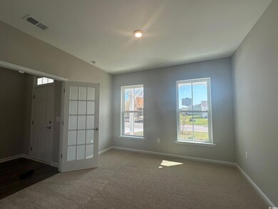 Foyer with carpet floors and lofted ceiling