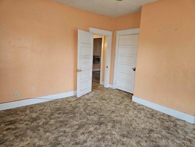 Spare room featuring light carpet and a textured c