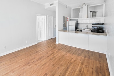 Spacious living room with wood-like flooring flows