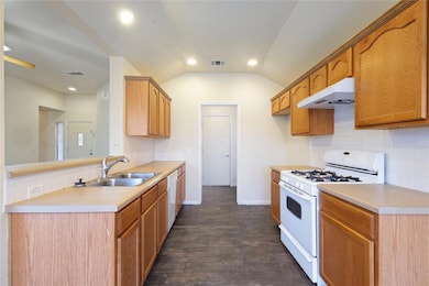 Kitchen featuring white appliances, extractor fan