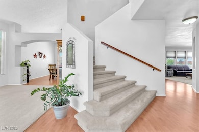 Staircase with wood finished floors, baseboards, a