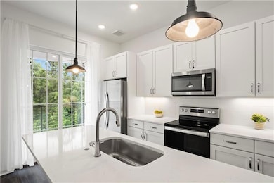 Kitchen with sink, a healthy amount of sunlight, b