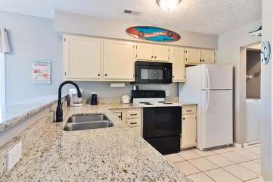 Kitchen featuring white appliances, a textured cei