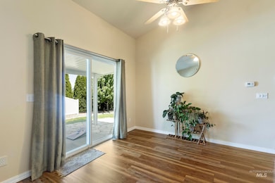 Spare room with wood finished floors, a ceiling fan, and lofted ceiling