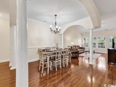 Dining room featuring ornate columns, wood finishe