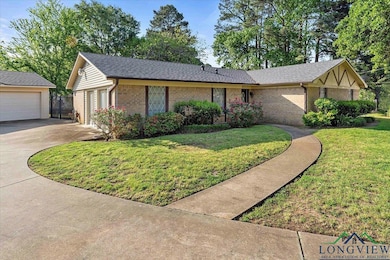 Ranch-style home with brick siding, a detached gar