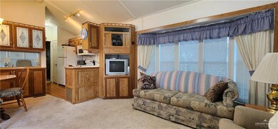 Living area with lofted ceiling and light carpet