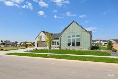 View of front facade with board and batten siding, a front yard, concrete driveway, and a garage