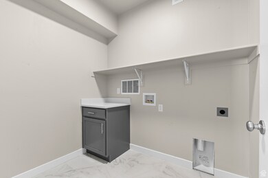 Laundry room featuring light marble finish flooring, washer hookup, and hookup for an electric dryer