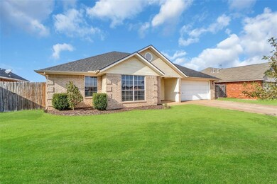 Ranch-style home featuring a front yard and a gara