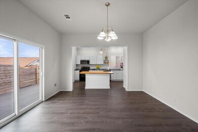 Kitchen with hanging light fixtures, dark hardwood / wood-style flooring, a center island, and butcher block counters