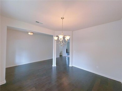 Unfurnished dining area with dark wood finished floors and a chandelier
