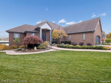 View of front of house with a front yard, brick siding, a chimney, and a shingled roof