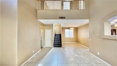 Unfurnished living room with stairs, light tile pa