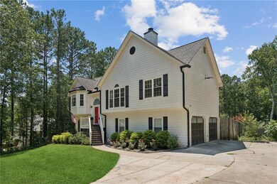 Raised ranch featuring concrete driveway, a garage, a chimney, and a shingled roof