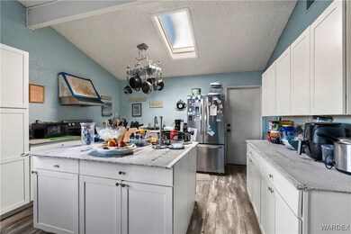 Kitchen with lofted ceiling with skylight, hardwoo