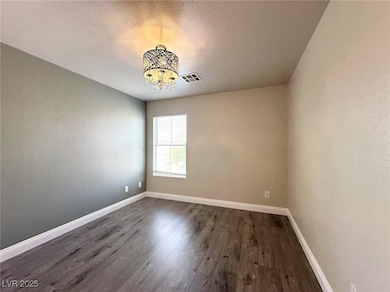 Unfurnished room featuring a chandelier and dark w