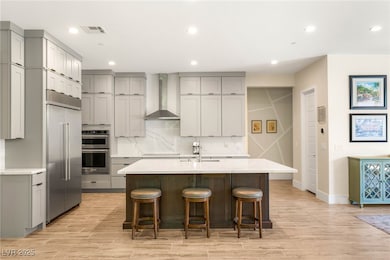 Kitchen featuring wall chimney exhaust hood, gray