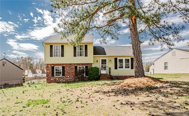 Tri-level home with brick siding, a front yard, an