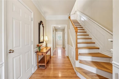 Foyer entrance with stairway, a wainscoted wall, a