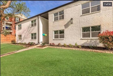 View of front of property with a front yard, brick