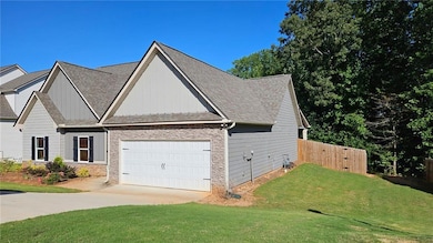 View of front of house featuring stone siding, concrete driveway, a shingled roof, and a garage