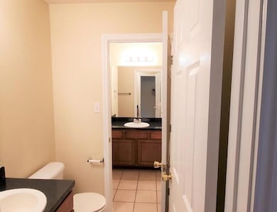 Half bathroom featuring vanity and tile patterned