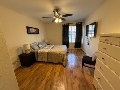 Bedroom with laminate-hardwood floors, a ceiling f