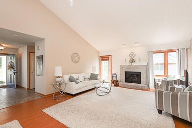 Great room featuring a healthy amount of sunlight, vaulted ceiling & fireplace