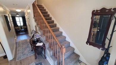 Staircase featuring crown molding and wood finished floors