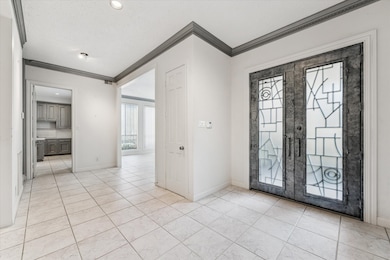 Another view of the spacious foyer and custom steel entry doors. The formal dining room is located on the right and entry into the kitchen on the left.