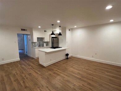 Kitchen with white cabinetry, tasteful backsplash, recessed lighting, decorative light fixtures, and a peninsula