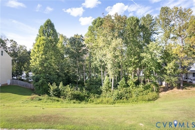 View of grassy yard with view of wooded area