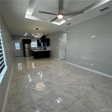 Unfurnished living room featuring light marble finish flooring, a ceiling fan, and a chandelier